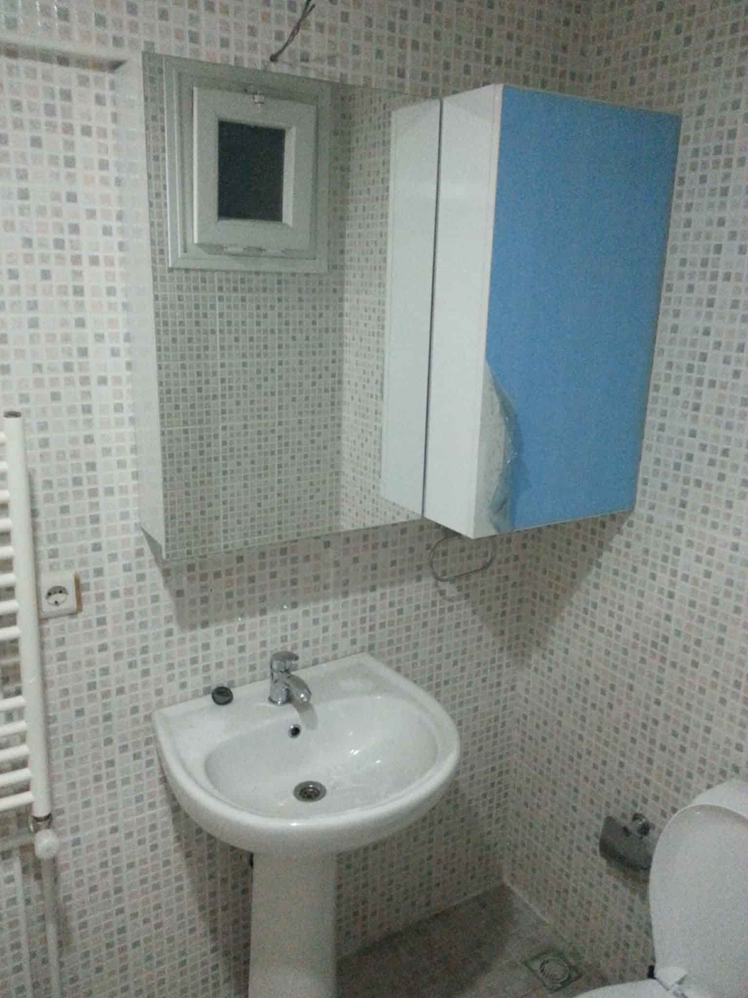 Küçük banyoda lavabo ve mavi dolap