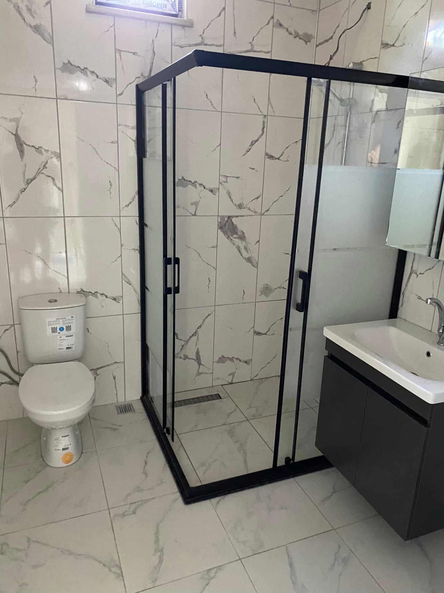 Mavi çerçeveli duş kabini ve banyo dolabı
